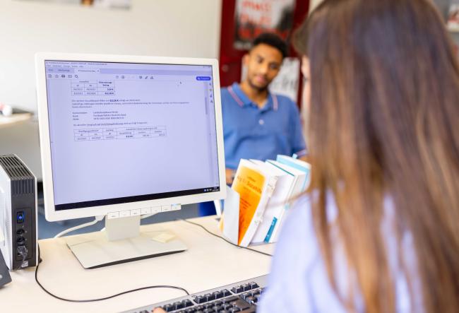 Clerk at her desk advising a student.