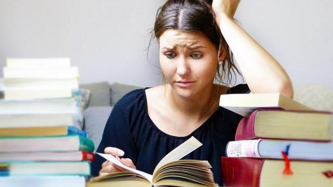 Confused student sitting at a desk with books