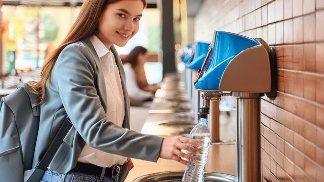 Student fills up a bottle of water at a canteen tap.