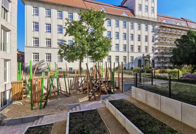 Outdoor area of the stW daycare centre at the BHT with a view of a university building of the BHT.