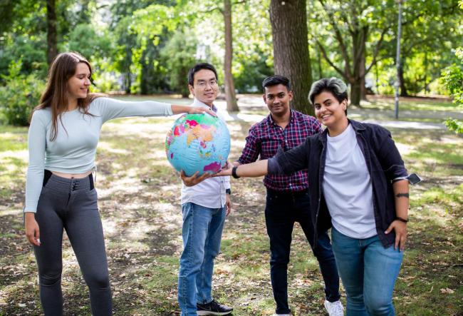 Students holding a world ball