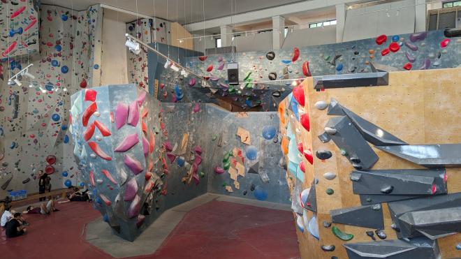 Eine Boulderhalle mit vielen knallbunten Elementen an der Kletterwand. 