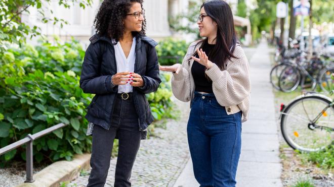 Two women standing and talking to each other