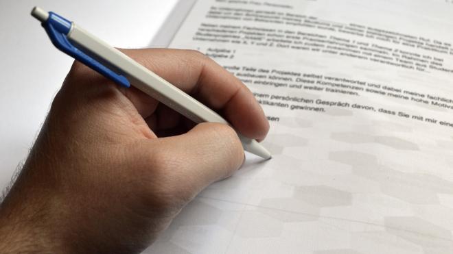 Close up of a hand writing on a piece of paper