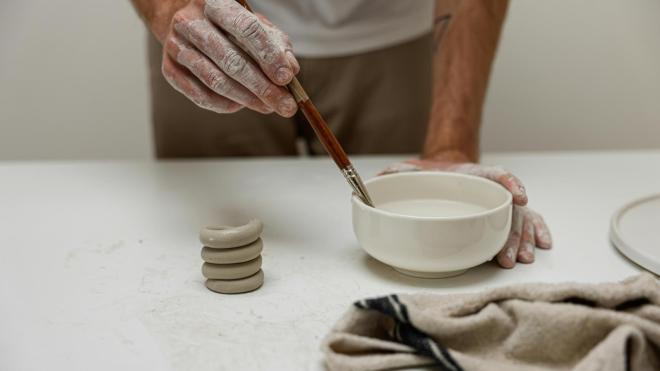 hands are modelling a clay pot